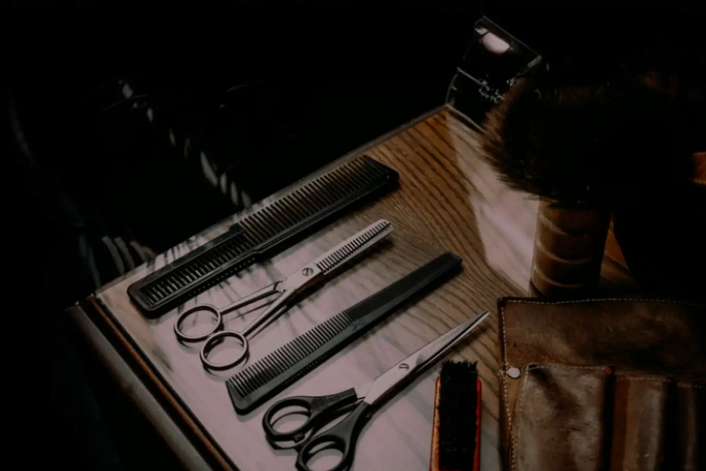 Parturi-kampaamo tarvikkeita ja leikkaussakset puisella pöydällä