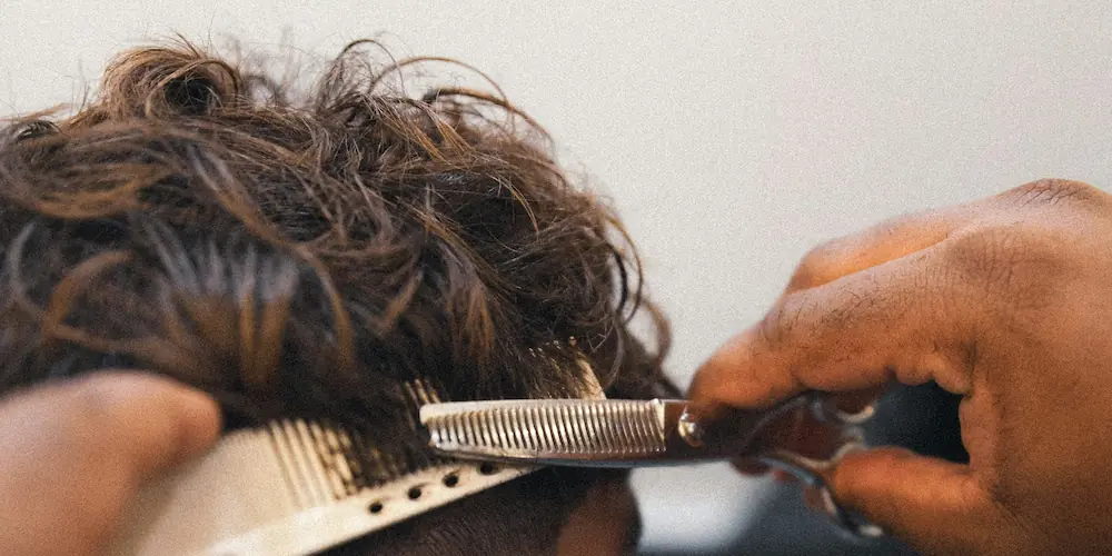 Hiuksia leikataan saksilla